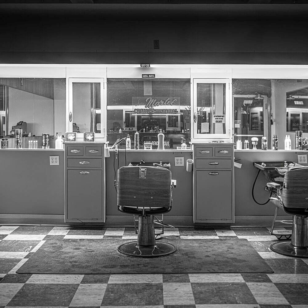 Barber chair on a checkered floor in an empty shop